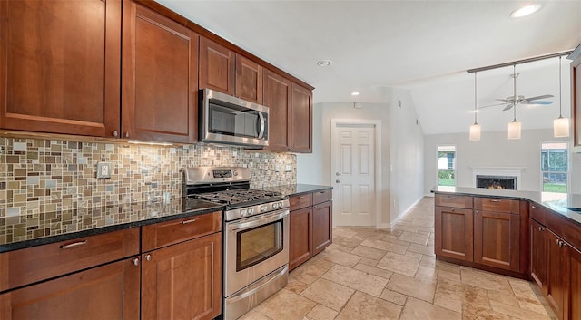 kitchen featuring tasteful backsplash, dark stone counters, stainless steel appliances, ceiling fan, and lofted ceiling