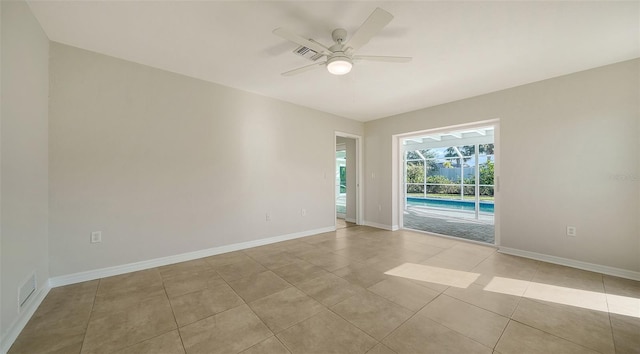 tiled empty room featuring ceiling fan