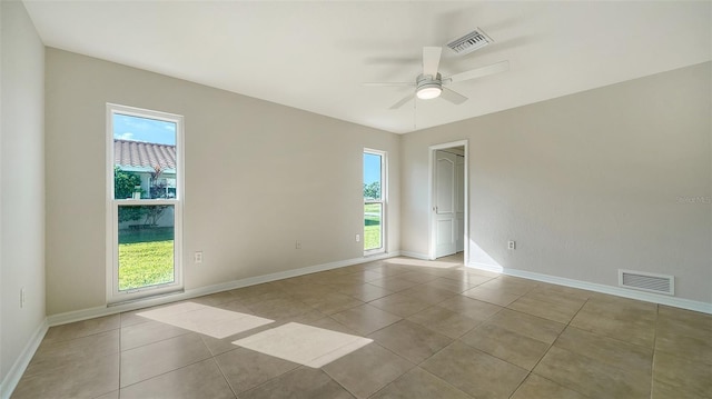 tiled spare room featuring ceiling fan