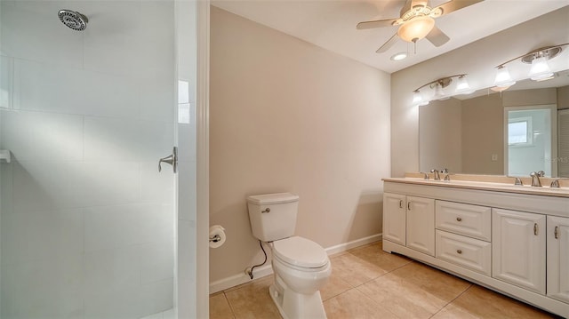 bathroom with ceiling fan, tile patterned floors, tiled shower, toilet, and vanity