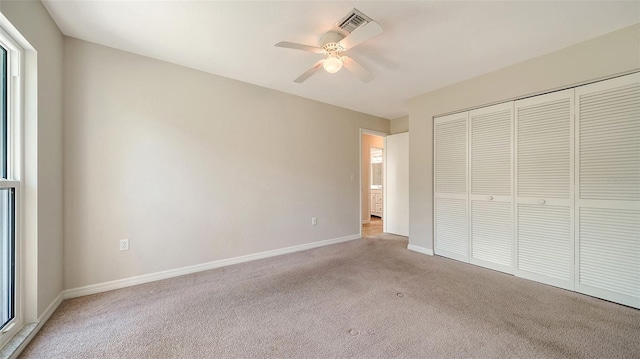 unfurnished bedroom with light carpet, a closet, and ceiling fan