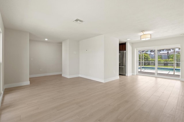 482 Rubens Dr E, Nokomis, FL 34275 - unfurnished living room featuring light wood finished floors and recessed lighting
