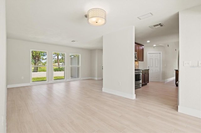 482 Rubens Dr E, Nokomis, FL 34275 - unfurnished living room with baseboards and light wood finished floors