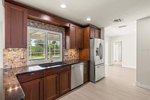 482 Rubens Dr E, Nokomis, FL 34275 - kitchen featuring stainless steel appliances, decorative backsplash, dark stone counters, and recessed lighting