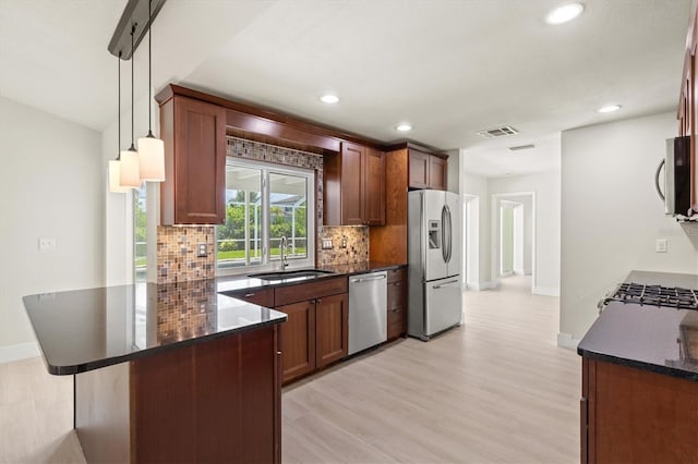 482 Rubens Dr E, Nokomis, FL 34275 - kitchen featuring appliances with stainless steel finishes, tasteful backsplash, recessed lighting, a peninsula, and light wood-type flooring