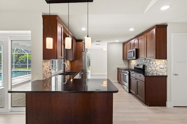 482 Rubens Dr E, Nokomis, FL 34275 - kitchen with appliances with stainless steel finishes, a peninsula, decorative backsplash, recessed lighting, and hanging light fixtures