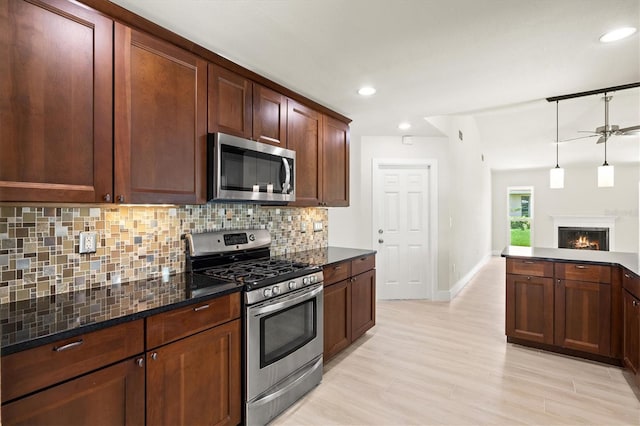 482 Rubens Dr E, Nokomis, FL 34275 - kitchen featuring appliances with stainless steel finishes, backsplash, dark stone countertops, pendant lighting, and recessed lighting