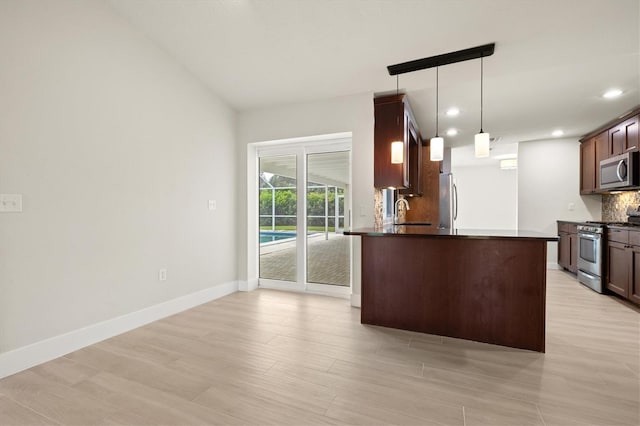 482 Rubens Dr E, Nokomis, FL 34275 - kitchen with appliances with stainless steel finishes, dark countertops, light wood finished floors, decorative backsplash, and recessed lighting