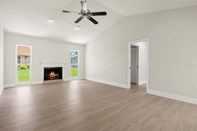 482 Rubens Dr E, Nokomis, FL 34275 - unfurnished living room featuring lofted ceiling, a ceiling fan, light wood finished floors, and a lit fireplace