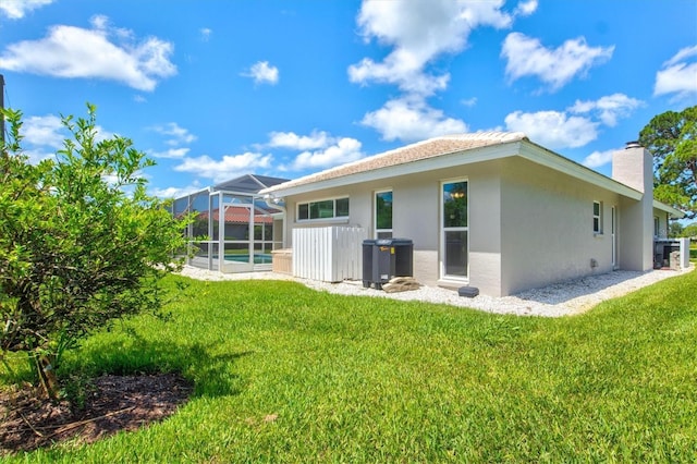 482 Rubens Dr E, Nokomis, FL 34275 - rear view of house featuring a chimney, a yard, a lanai, and stucco siding