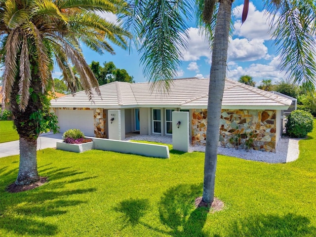 482 Rubens Dr E, Nokomis, FL 34275 - ranch-style home featuring stone siding, a front yard, a garage, and concrete driveway