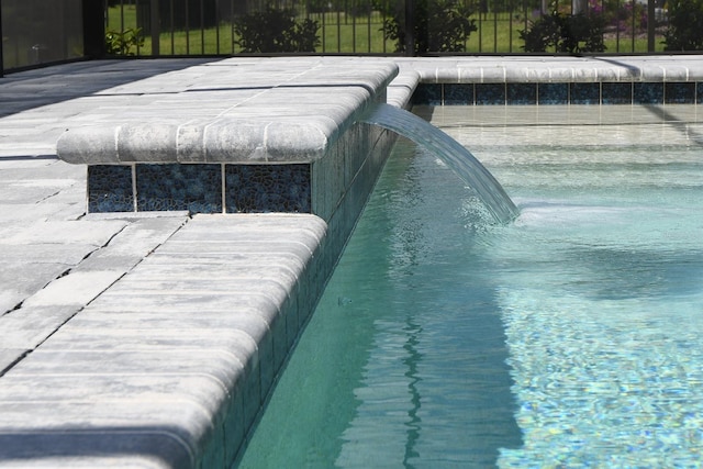 view of swimming pool with pool water feature