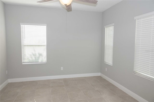 spare room with ceiling fan and light tile patterned flooring