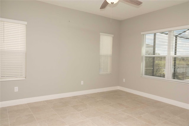 tiled spare room featuring ceiling fan