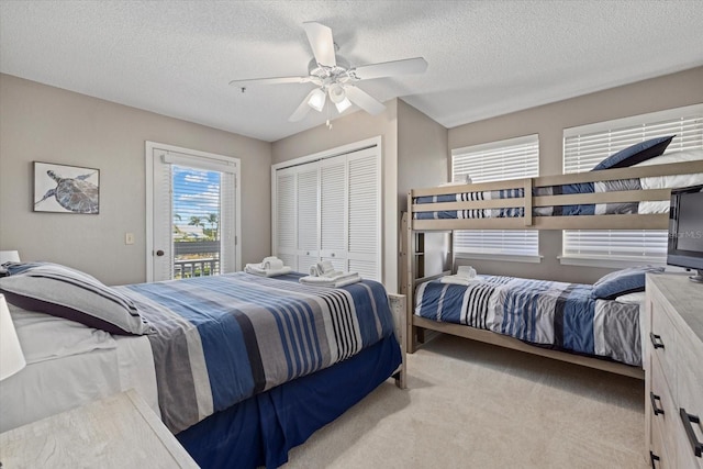 carpeted bedroom with a closet, a textured ceiling, ceiling fan, and access to outside