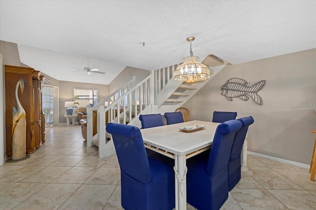 dining area with ceiling fan with notable chandelier, a textured ceiling, and light tile patterned floors