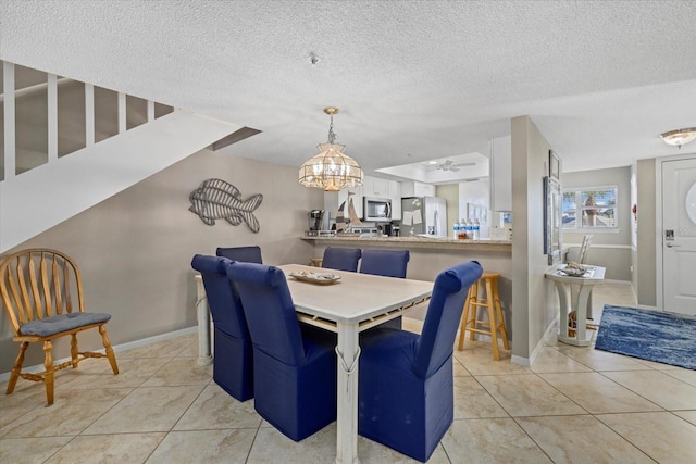 dining space featuring ceiling fan, a textured ceiling, and light tile patterned floors