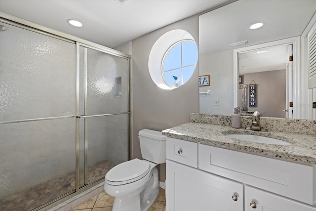 bathroom featuring toilet, a shower with door, vanity, and tile patterned floors