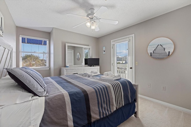 bedroom with ceiling fan, light carpet, and a textured ceiling