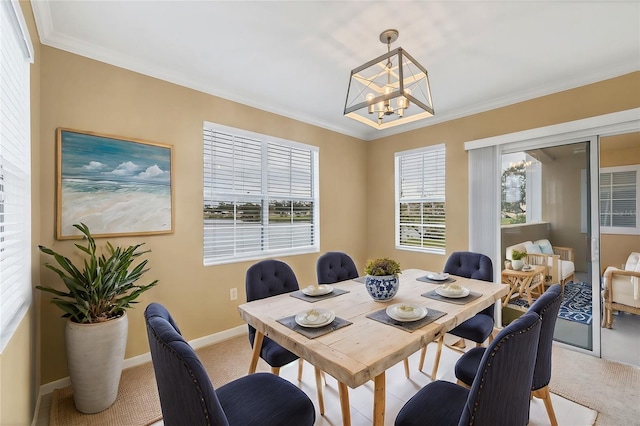 carpeted dining space featuring ornamental molding and a chandelier