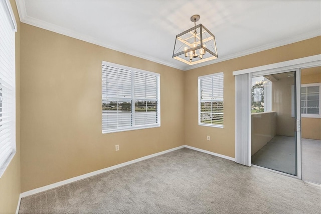 carpeted empty room featuring ornamental molding and a notable chandelier