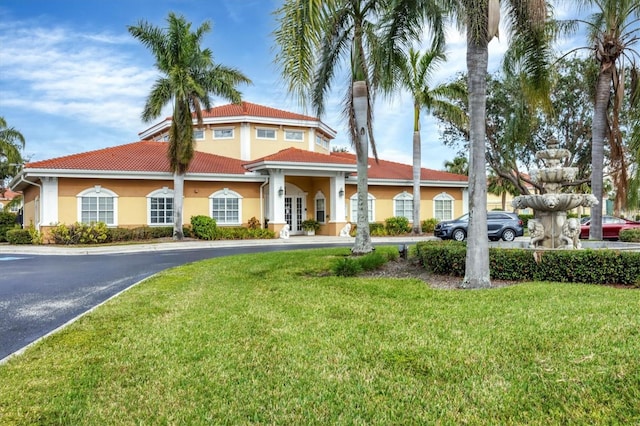 mediterranean / spanish home featuring a front lawn