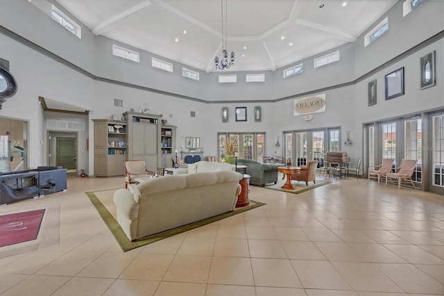 tiled living room featuring a towering ceiling, french doors, and a chandelier