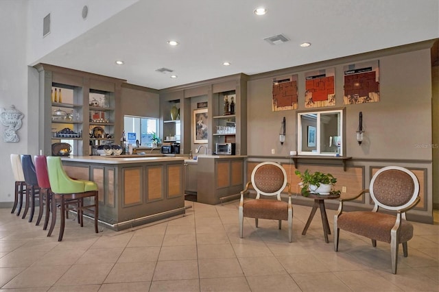 bar with light tile patterned flooring, built in features, and crown molding