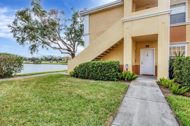 view of exterior entry with a yard and a water view