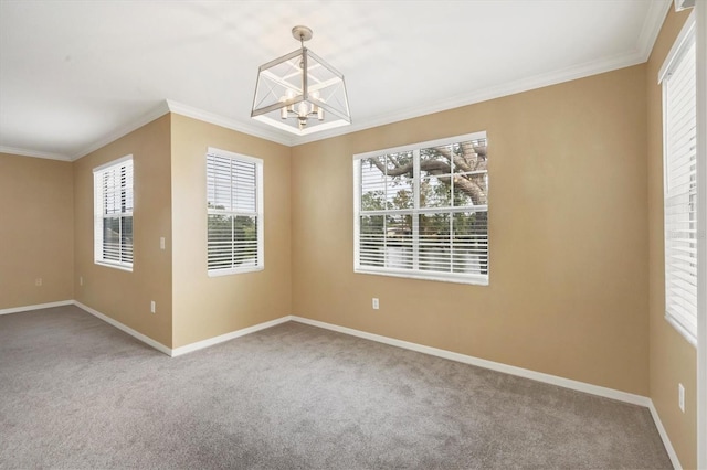 spare room with a chandelier, carpet flooring, and ornamental molding