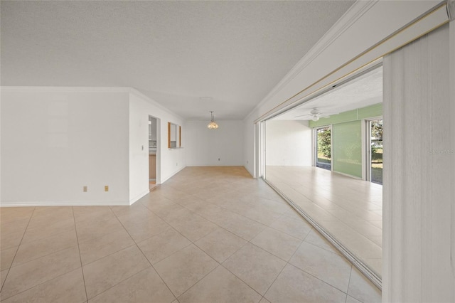 empty room with a textured ceiling, light tile patterned flooring, crown molding, and ceiling fan with notable chandelier