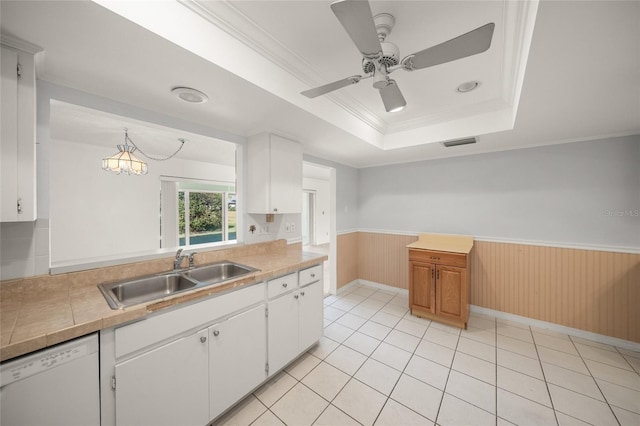 kitchen featuring a raised ceiling, crown molding, white cabinetry, white dishwasher, and sink