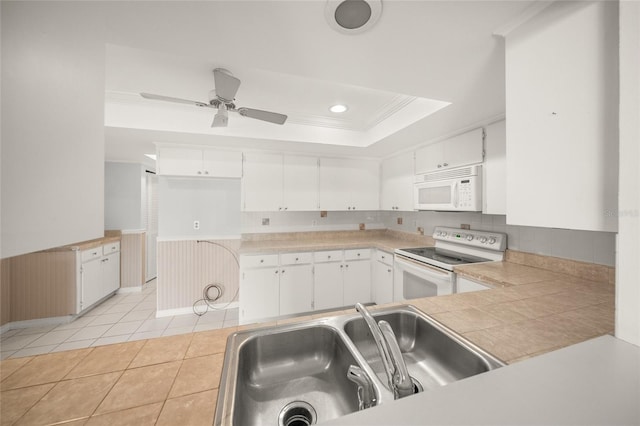 kitchen with white appliances, sink, light tile patterned flooring, and white cabinetry