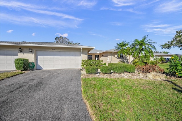 ranch-style home featuring a front lawn and a garage