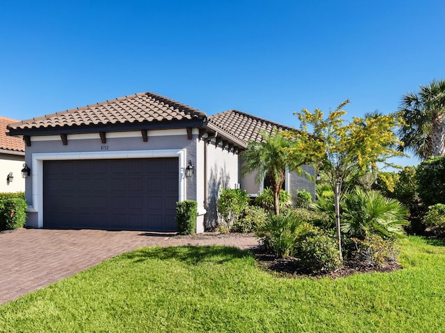 mediterranean / spanish home with a garage and a front lawn