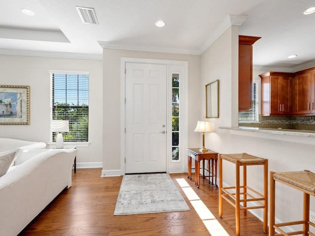 entryway featuring hardwood / wood-style flooring and crown molding