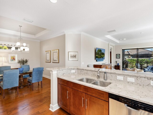 kitchen featuring pendant lighting, sink, stainless steel dishwasher, dark hardwood / wood-style floors, and a tray ceiling