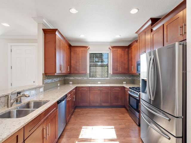 kitchen featuring appliances with stainless steel finishes, backsplash, light stone counters, and sink