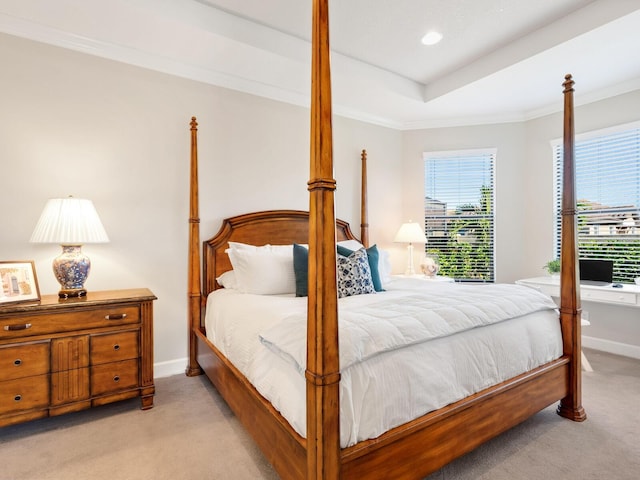 bedroom with a tray ceiling, light carpet, and crown molding