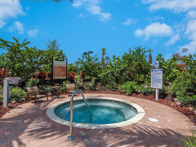 view of swimming pool with a hot tub