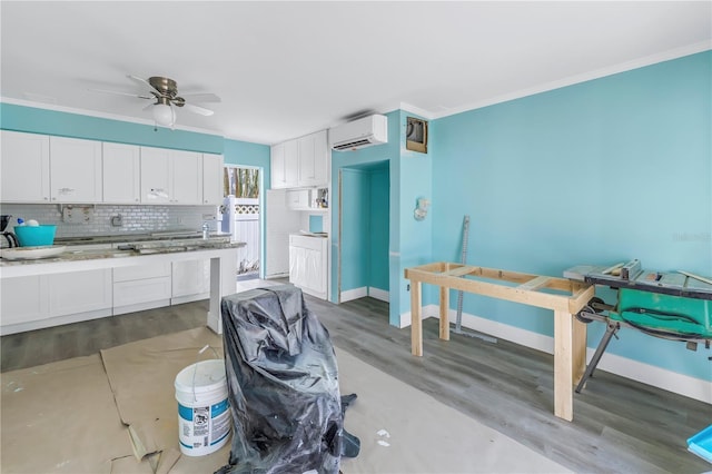 kitchen with a wall mounted air conditioner, decorative backsplash, ceiling fan, hardwood / wood-style flooring, and white cabinetry