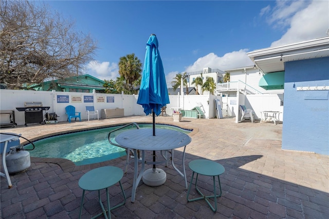 view of swimming pool featuring a patio area and grilling area