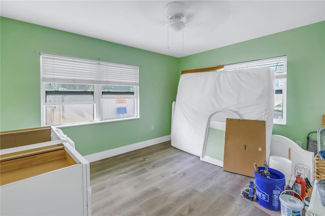 bedroom featuring multiple windows, ceiling fan, and light wood-type flooring