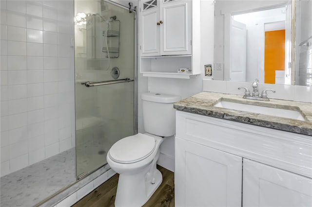 bathroom featuring hardwood / wood-style floors, vanity, toilet, and walk in shower