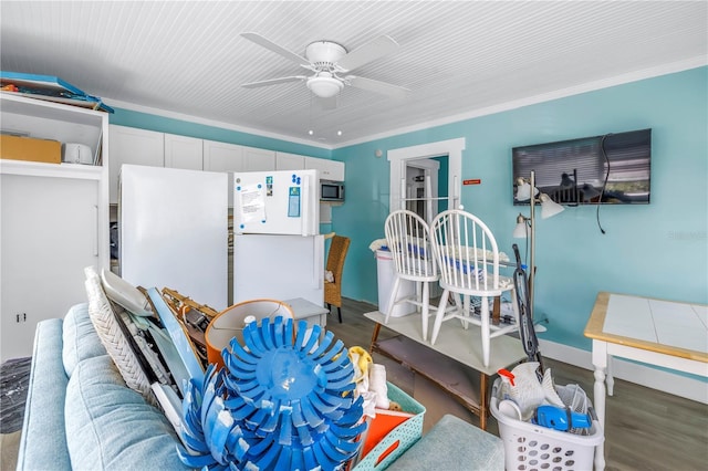 interior space with crown molding, ceiling fan, white fridge, and dark hardwood / wood-style floors