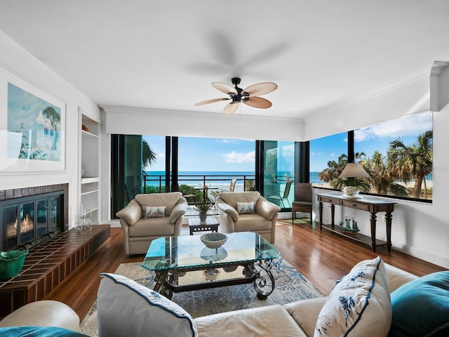 living room featuring ceiling fan, built in features, a water view, and hardwood / wood-style flooring