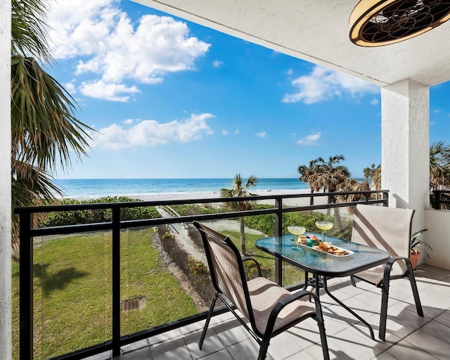 balcony featuring a view of the beach and a water view