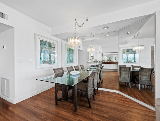 dining area featuring dark wood-type flooring and a chandelier