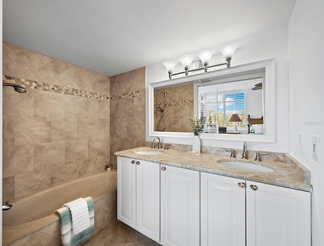 bathroom with vanity, tiled shower / bath combo, and tile patterned flooring