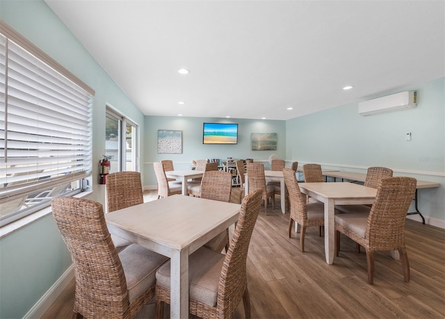 dining space featuring wood finished floors, recessed lighting, and a wall unit AC